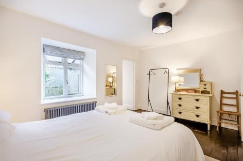 a white bedroom with two beds and a dresser at 5 Bed in Ulpha oc-b32731 in Ulpha