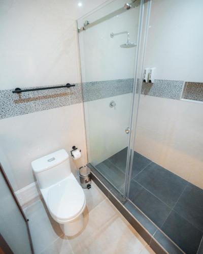 a bathroom with a toilet and a glass shower at Hotel Nilas in Tarapoto