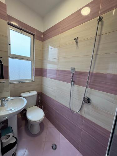 a bathroom with a shower and a toilet and a sink at Mesdheu ApartHotel in Durrës