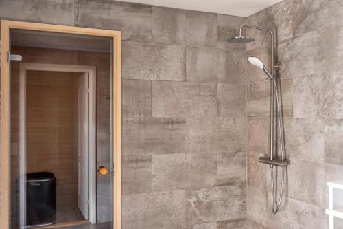 a shower in a bathroom with a glass door at Austurey - Lakefront Villa in Laugarvatn