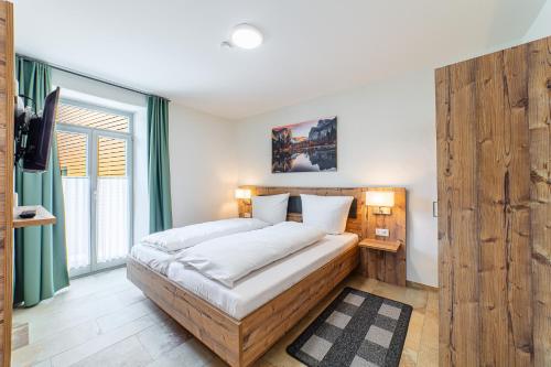 a bedroom with a large bed and a large window at Apartment mit Terrasse "Blumentraum" in Spalt