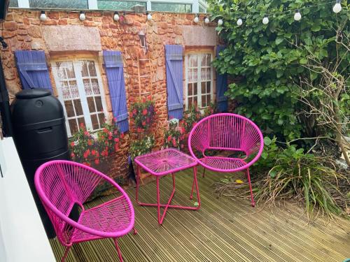 three pink chairs and a trash can on a patio at Double Bedroom with Private Entrance in Weymouth
