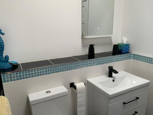 a white bathroom with a sink and a mirror at Double Bedroom with Private Entrance in Weymouth