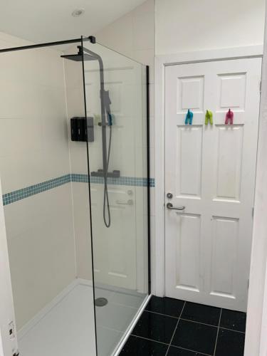 a shower with a glass door in a bathroom at Double Bedroom with Private Entrance in Weymouth