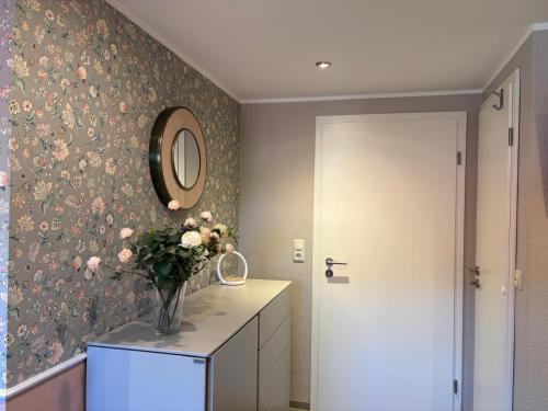 a bathroom with a vase of flowers on a dresser at Wohnung Burghaus 3 OG in Krummhörn