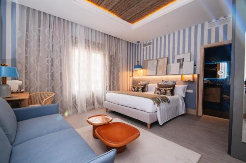 a hotel room with a bed and a couch at Nomada House by SH Hoteles in Denia