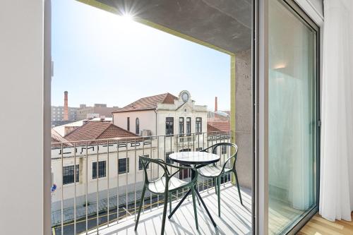 a balcony with a table and a view of a building at GuestReady - Menéres Apartments in Matosinhos
