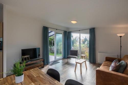 a living room with a couch and a table at Welcome in - Vakantiepark Fort den Haak - 2 huisdieren toegestaan - Dichtbij strand en Veerse Meer in Vrouwenpolder
