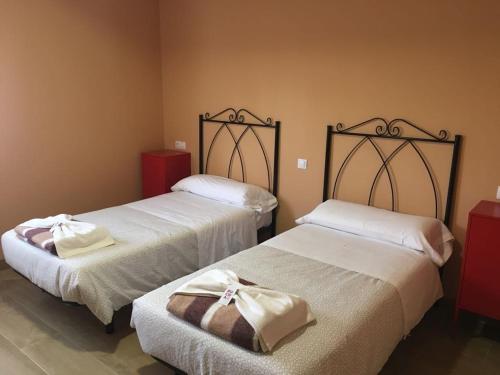 two beds sitting next to each other in a room at Albergue La Perala in Bercianos del Real Camino