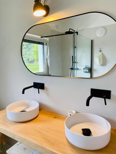 a bathroom with two sinks on a wooden counter with a mirror at Como Lake Dreamscape Villa in Cernobbio