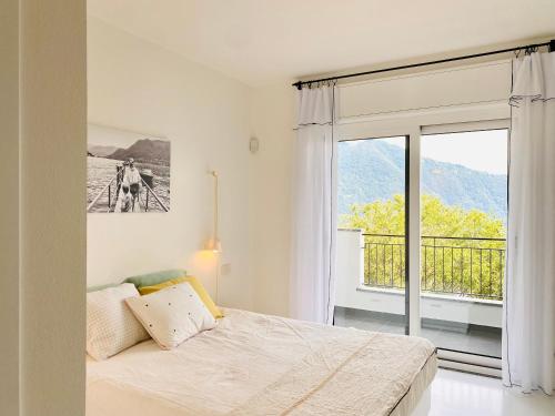 a bedroom with a bed and a large window at Como Lake Dreamscape Villa in Cernobbio
