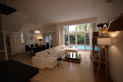 a living room with a white couch and a table at Luxury 4BR New Cairo Villa with Pool & Stylish Living - FAMILY ONLY in Cairo