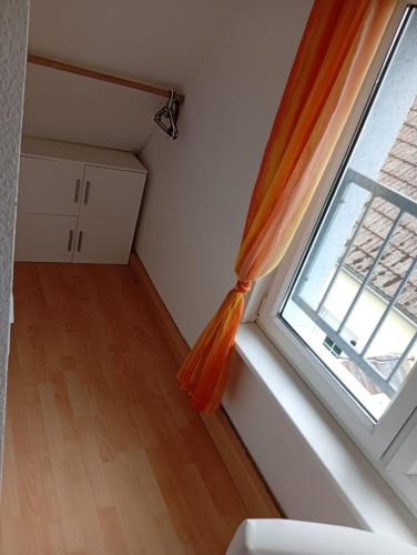 a room with a window with an orange curtain at Ferienhaus Boddensicht in Breege