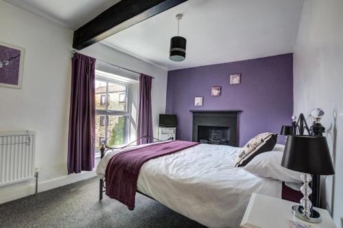 a purple bedroom with a bed and a fireplace at 2 Bed in Skipton oc-ds221 in Skipton