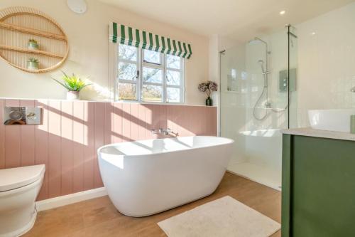 a bathroom with a tub and a toilet and a sink at 2 Bed in Dennington oc-b28093 in Dennington