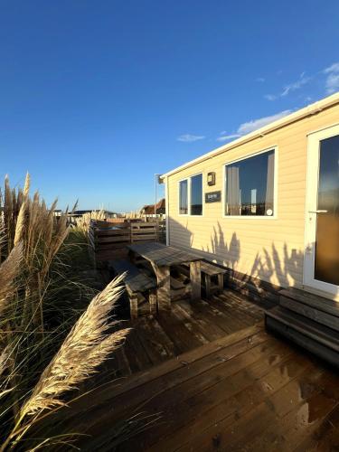 a wooden deck with benches and a trailer at Chalet 91 Retro in Westerland