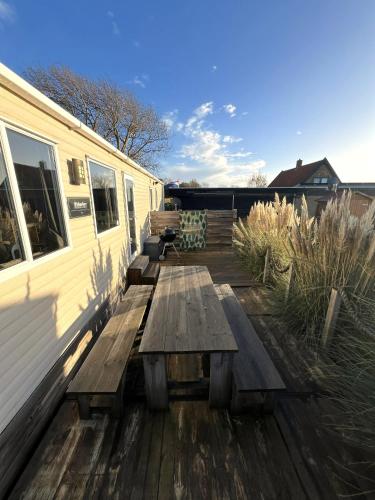 a wooden deck with benches and a trailer at Chalet 91 Retro in Westerland