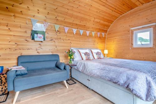 a bed and a chair in a room with wooden walls at 1 Bed in Cross oc-s29656 in Axbridge