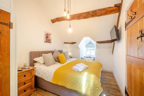 a bedroom with a bed with yellow sheets and a dresser at 2 Bed in Penmaenpool oc-p32333 in Penmaenpool