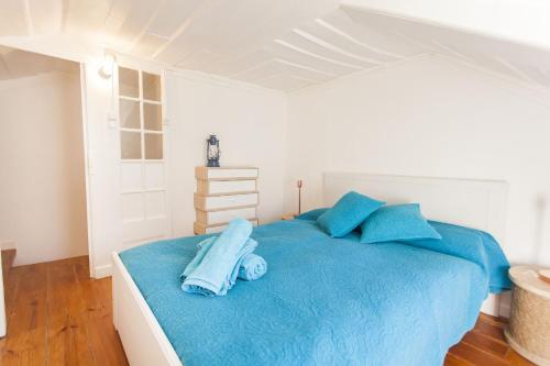 um quarto com uma cama azul com almofadas azuis em LovelyStay - Cosy Bairro Alto Duplex em Lisboa