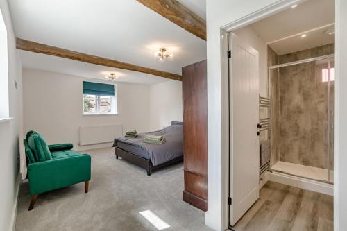 a bedroom with a bed and a green chair at 5 Bed in Roxwell oc-t30824 in Roxwell