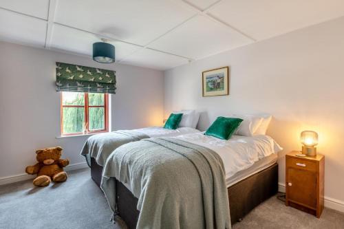 a bedroom with a large bed and a teddy bear at 4 Bed in Burrowbridge oc-o33020 in Athelney