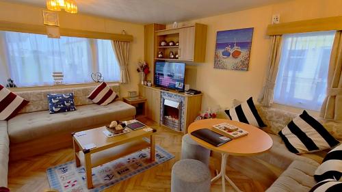 a living room with a couch and a table at MOLLIES DEN 3 8 Berth 3 bedroom Waterside Leisure Park INGOLDMELLS in Ingoldmells