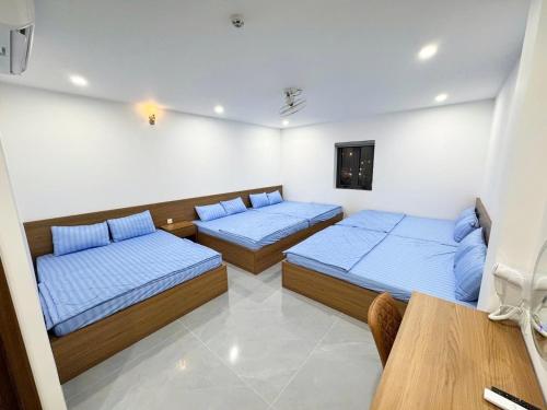 a room with two beds and a table in it at THANH THỦY HoTel in Hà Tiên