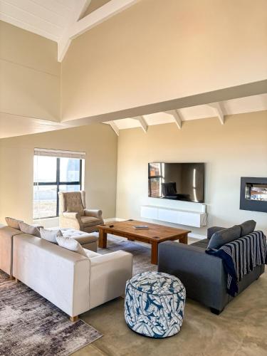 a living room with two couches and a table at Casa Costeira in Britannia Bay