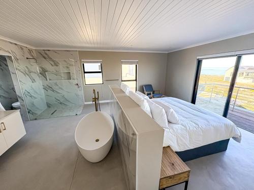 a bedroom with a large bed and a large window at Casa Costeira in Britannia Bay
