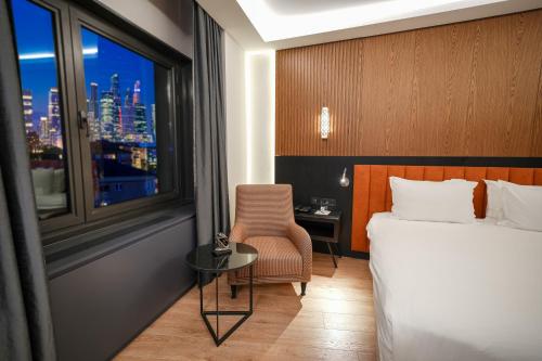 a hotel room with a bed and a desk and a window at Surmeli Istanbul Hotel in Istanbul
