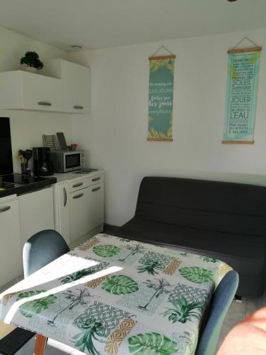 a small room with a table and a kitchen at Meublé de vacances, Quend-Plage in Quend-Plage