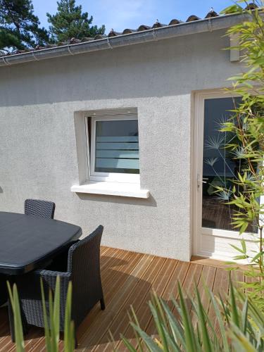 a patio with a window and a table and chairs at Meublé de vacances, Quend-Plage in Quend-Plage