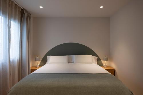 a bedroom with a large bed and a window at Apartamentos Boutique Casco Histórico in Las Lagunas
