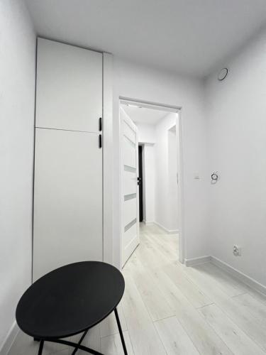 a white room with a black table and a closet at Lubicz Dolny, A1 Apartament 2 pokojowy in Lubicz