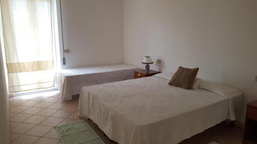 a bedroom with two beds and a window at Casa Vacanze Capoterra in Capoterra