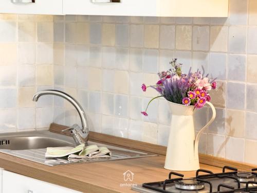 a vase of flowers sitting on a kitchen counter at Residenza Centrale in Villasimius