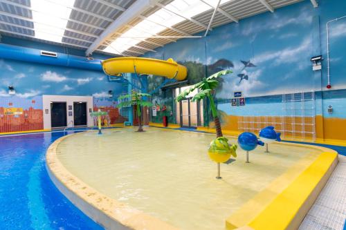 a pool with a slide in a swimming pool at Billing Aquadrome Holiday Park in Great Billing