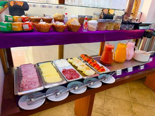 a purple table filled with different types of food at Pousada Vison Ubatuba - Praia Grande in Ubatuba