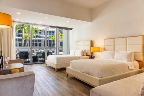 a hotel room with two beds and a balcony at The Grayson Hotel Miami Downtown in Miami