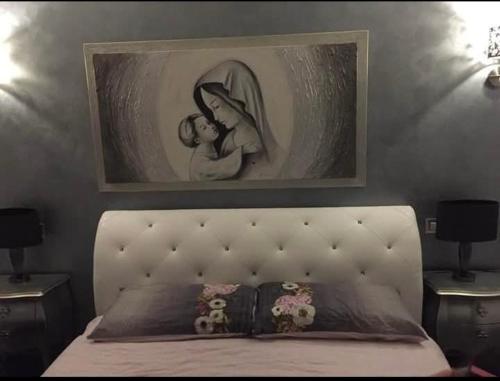 a bedroom with a bed with a picture on the wall at Acquamarina Luxury House in Budoni