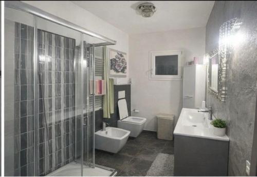 a bathroom with two toilets and a sink and a shower at Acquamarina Luxury House in Budoni