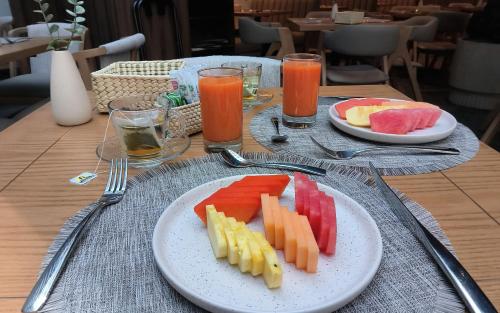 stół z dwoma talerzami owoców i napojów w obiekcie Hotel Block Suites w mieście Meksyk