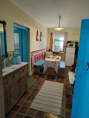 a living room with a table and a kitchen at Görbe Vendégház in Tarcal