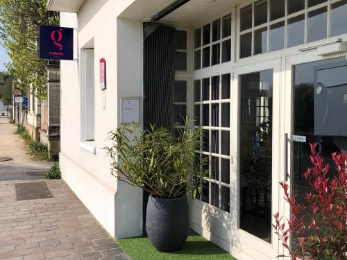 a building with a potted plant on the side of it at Gabriel Hotel Chinon in Chinon