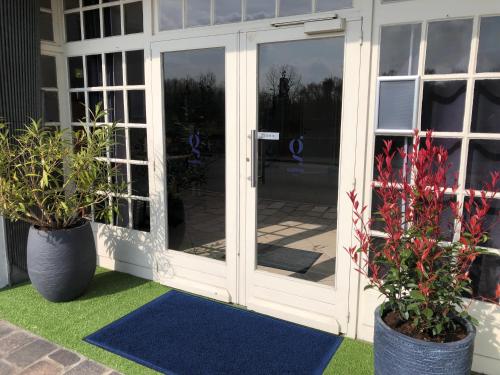 an open door with two potted plants on a patio at Gabriel Hotel Chinon in Chinon
