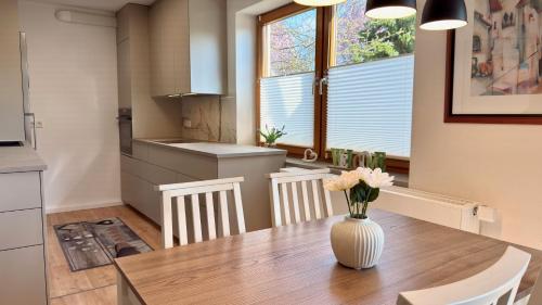 a kitchen with a table with a vase of flowers on it at Ferienwohnung Reuscher, Trier-Newel in Newel