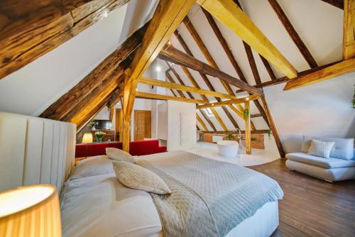 a bedroom with a large bed and a chair at Hotel Svambersky dum in Český Krumlov