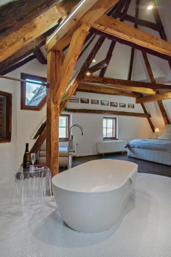 a large white bath tub in a kitchen with wooden ceilings at Hotel Svambersky dum in Český Krumlov