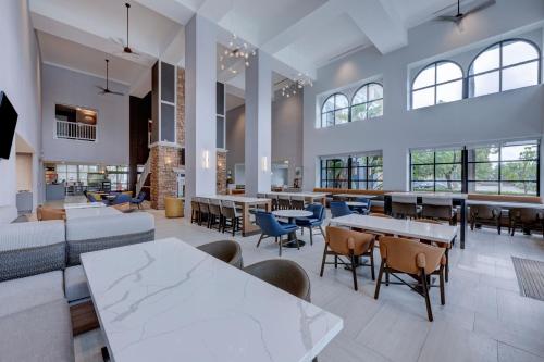 a large room with tables and chairs and windows at Homewood Suites by Hilton-Anaheim in Anaheim